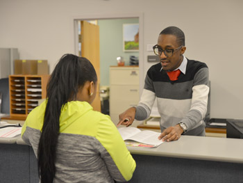 Image of a woman being helped at KCC's financial aid desk that links to KCC's Financial Aid Home page.